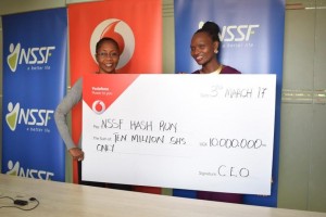 Marketing Director,Progress Chisenga(left handover dummy cheque worth Ugx10million to NSSF Marketing Director Barbara Teddy Arimi at the NSSF offices recently. 