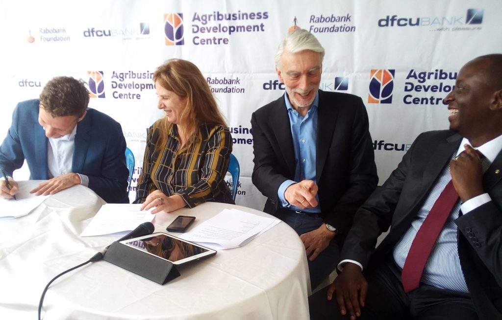 Van den Bosch (left) puts pen to paper together with Feijter witnessed by Moll and dfcu Bank executive director, William Sekabembe