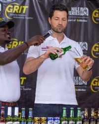 Adu Rando (R) the Managing Director, Nile Breweries demonstrates to trainees how to correctly serve beer during the training